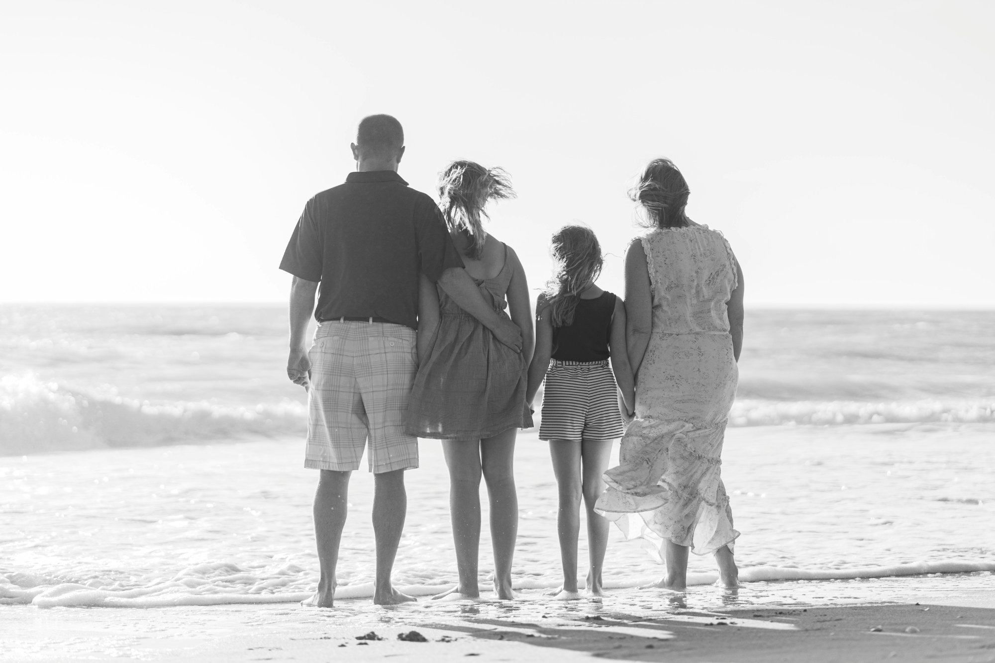 Familie am Strand, gemeinsam in eine Richtung schauend